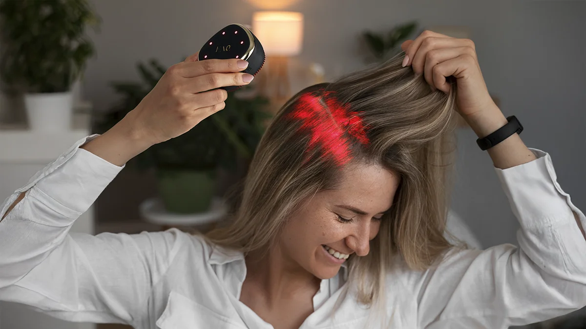 A woman dmonstrating red light therapy hair growth on the FAQ 302 laser hair growth device 